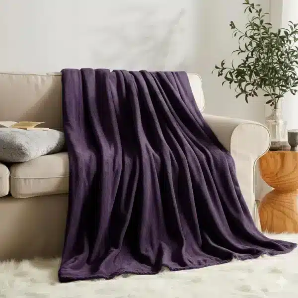 Luxurious aubergine faux fur blanket with plush fleece backing, perfect for sofa or bed decor.