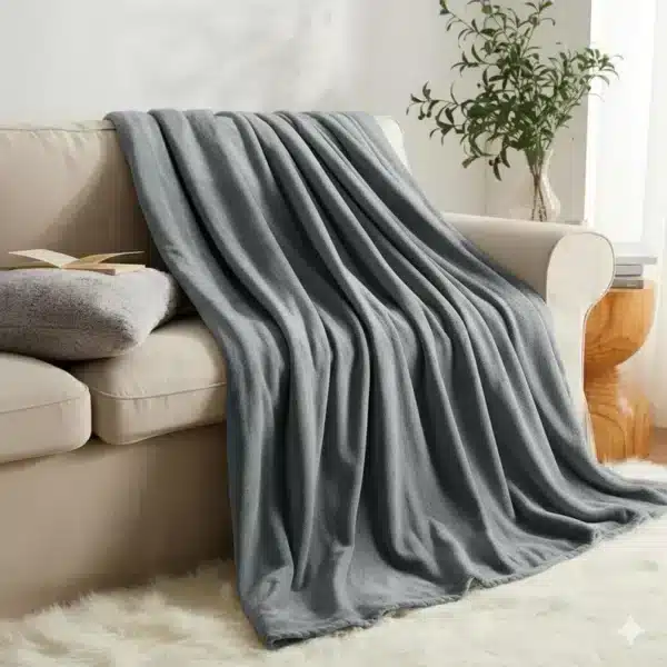 Stylish grey faux fur blanket with reversible fleece design, ideal for a modern sofa or bed setup.