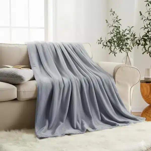 Modern silver faux fur throw blanket with reversible fleece texture, perfect for sofa or bed styling.