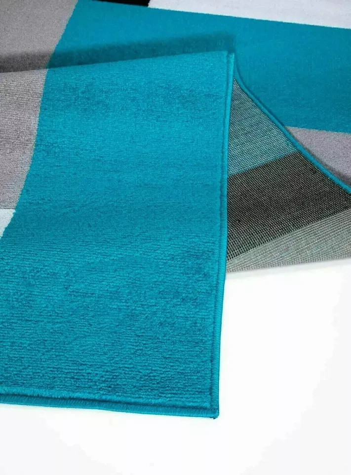 Folded corner of Teal Black Kilas Geometric Rug showing pile and backing Rugstars UK